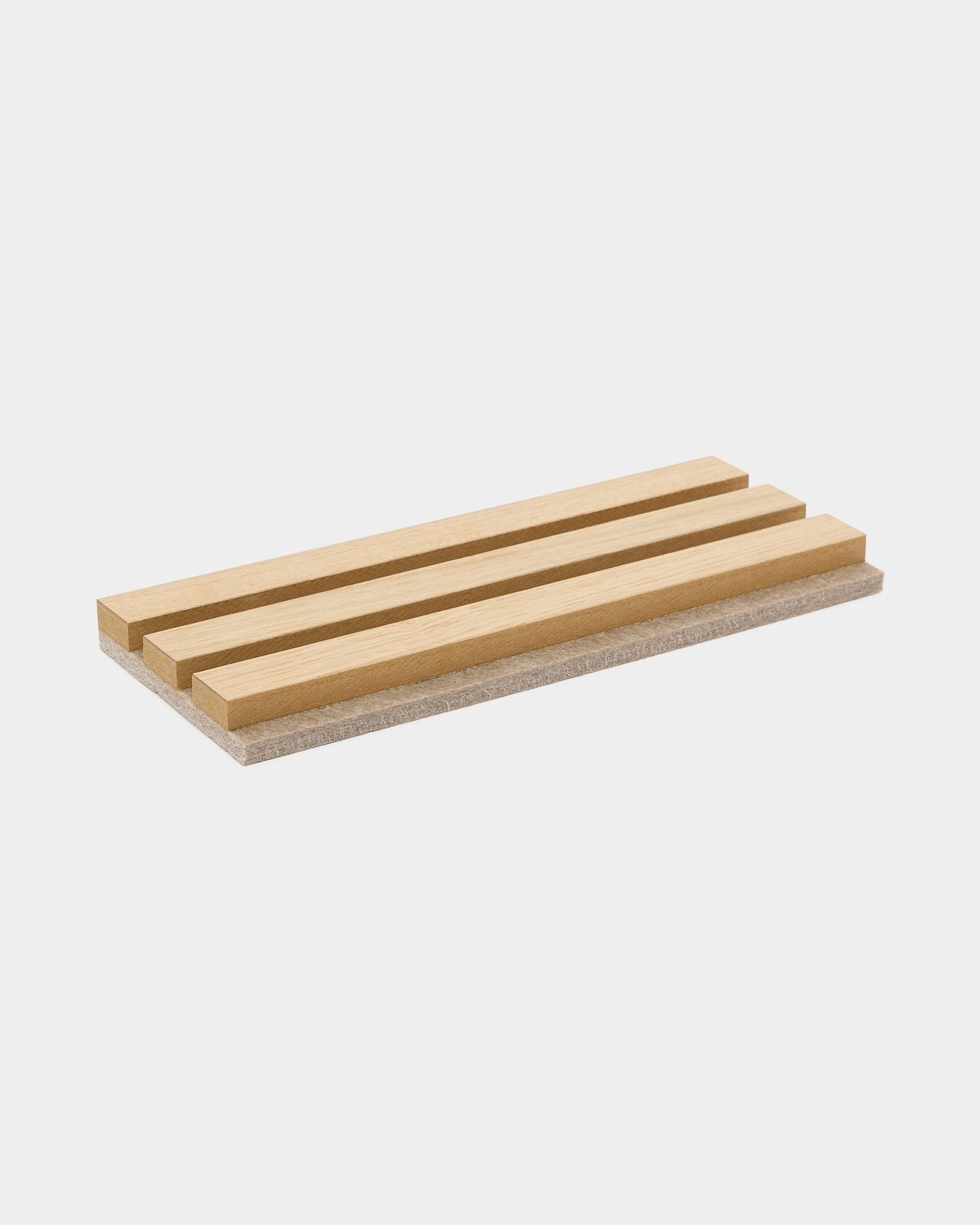 Akupanel oak acoustic slat sample on light grey felt, plain white background