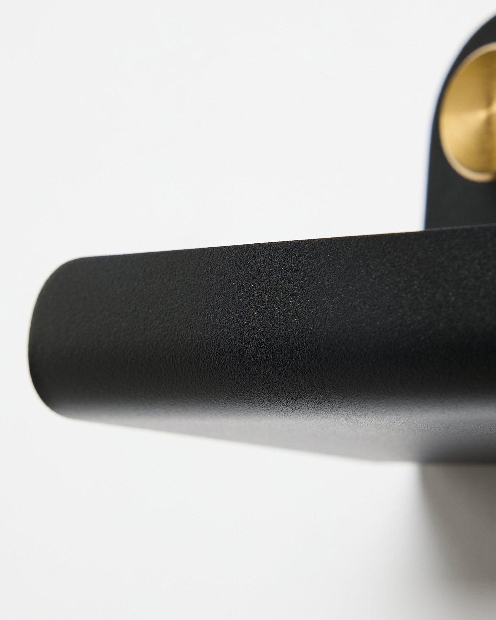 Norr narrow shelf in black with brass mounting detail on plain white background.
