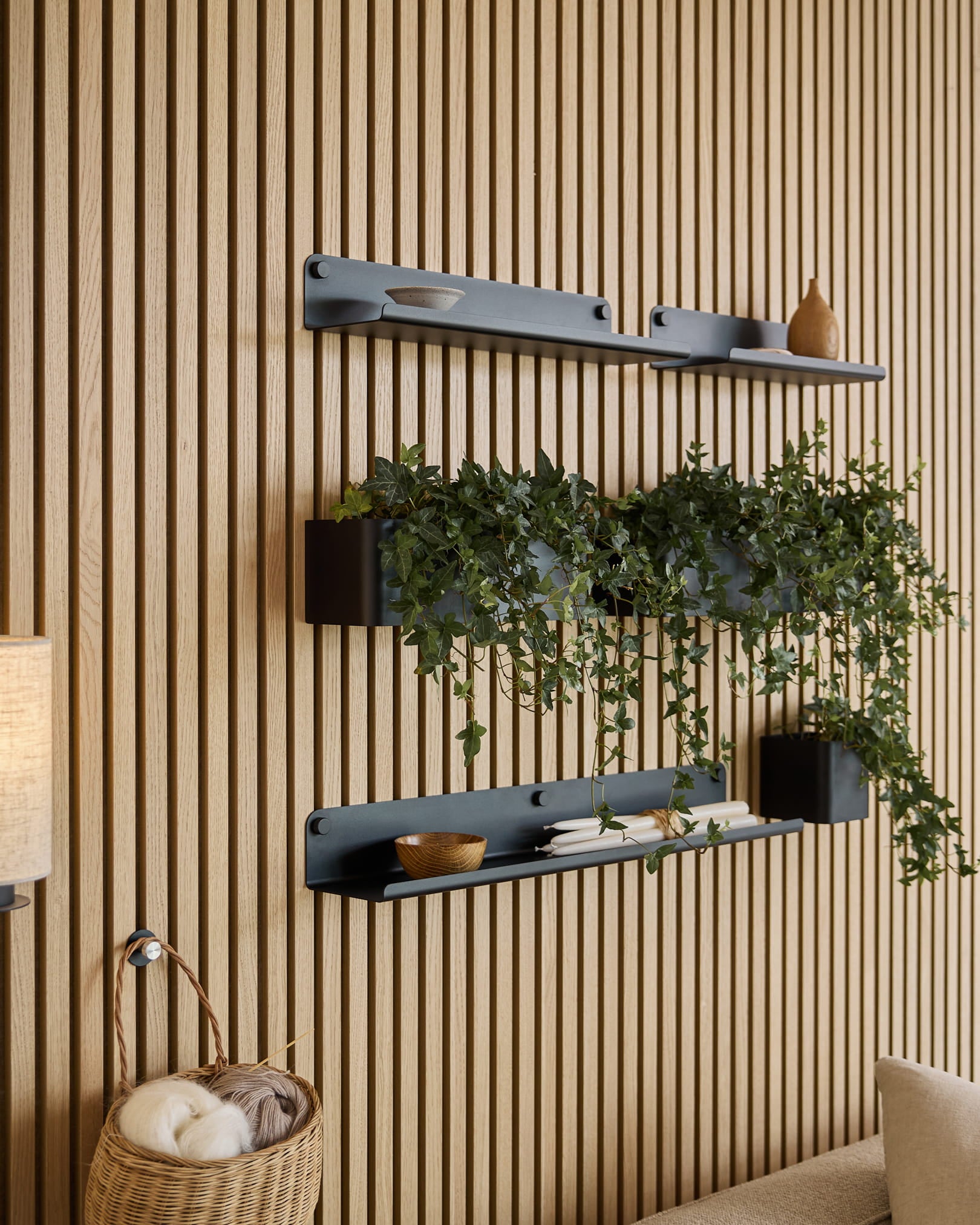 Black Norr plant box shelves with trailing ivy mounted on wood acoustic slat wall