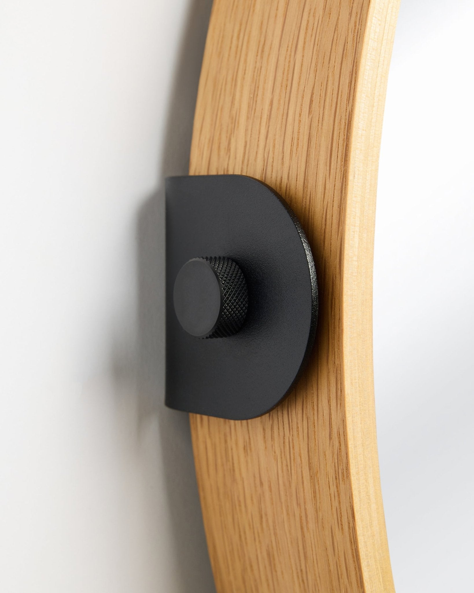 Linn mirror frame in natural oak with black metal bracket and knurled knob on plain white background