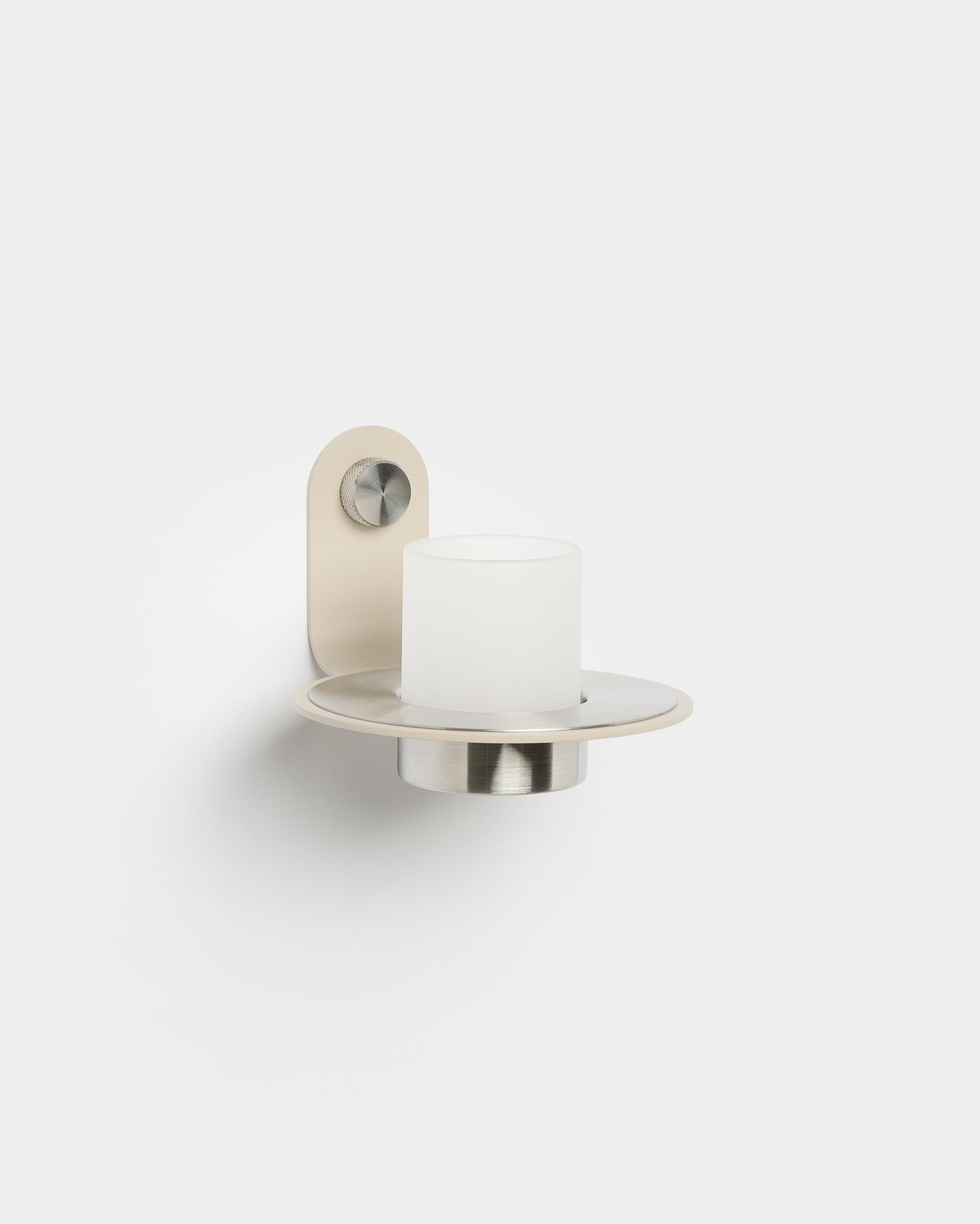 Norr wall-mounted candle holder in beige metal with frosted glass cup on plain white background