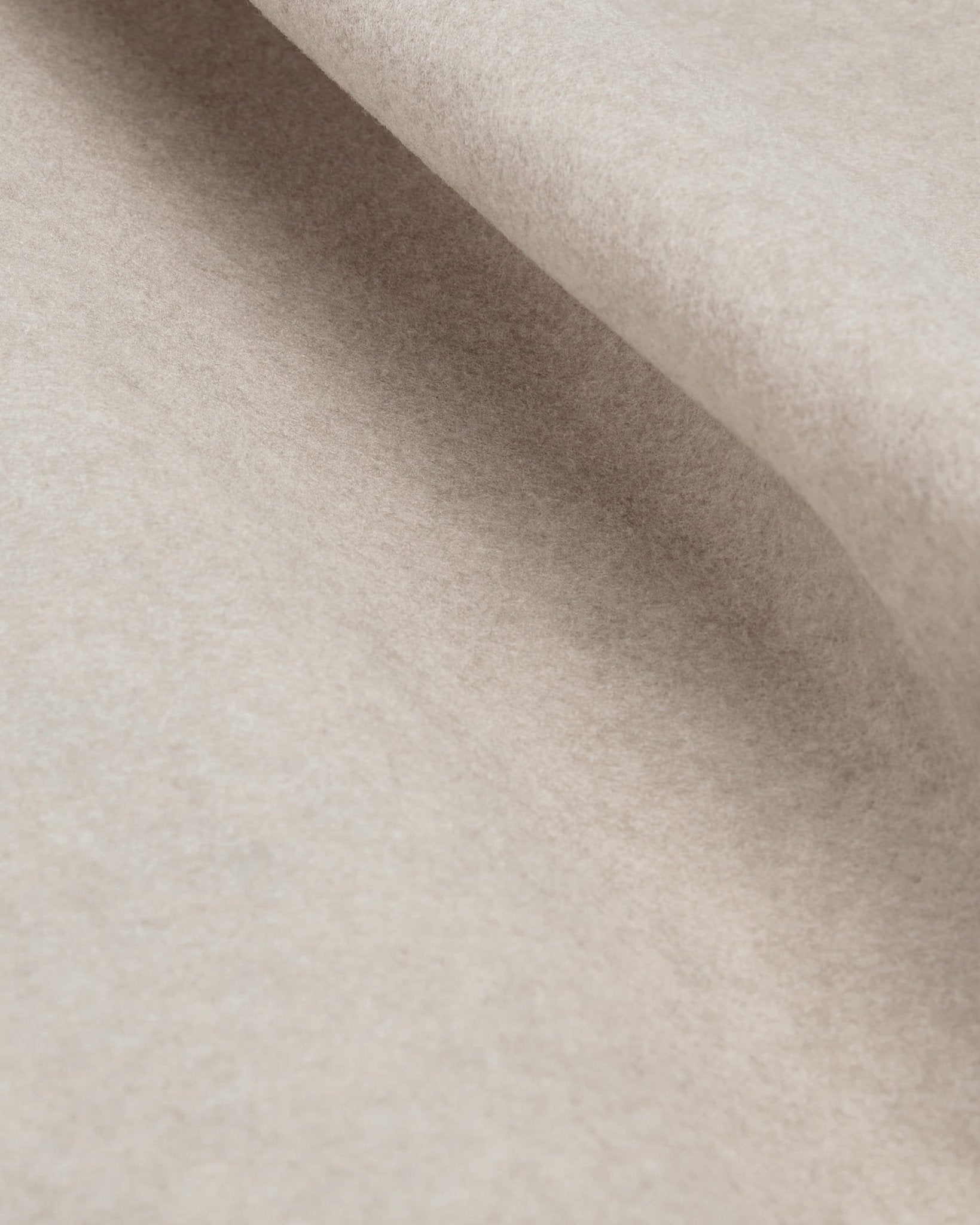 Close-up of WoodUpp Vigg Felt Sheet, 58 x 241 cm in light beige, highlighting its soft texture and subtle folds under varied lighting.
