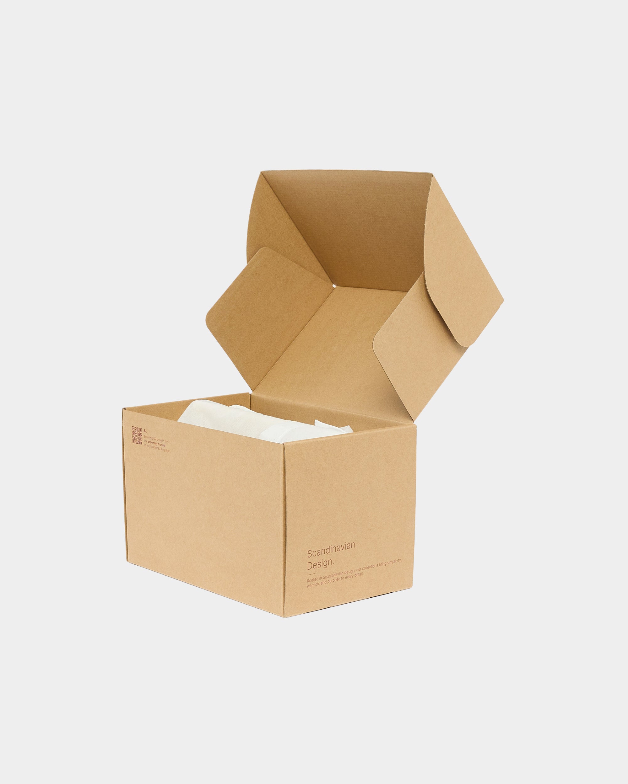 Open brown cardboard box with white tissue paper on a plain light grey background.