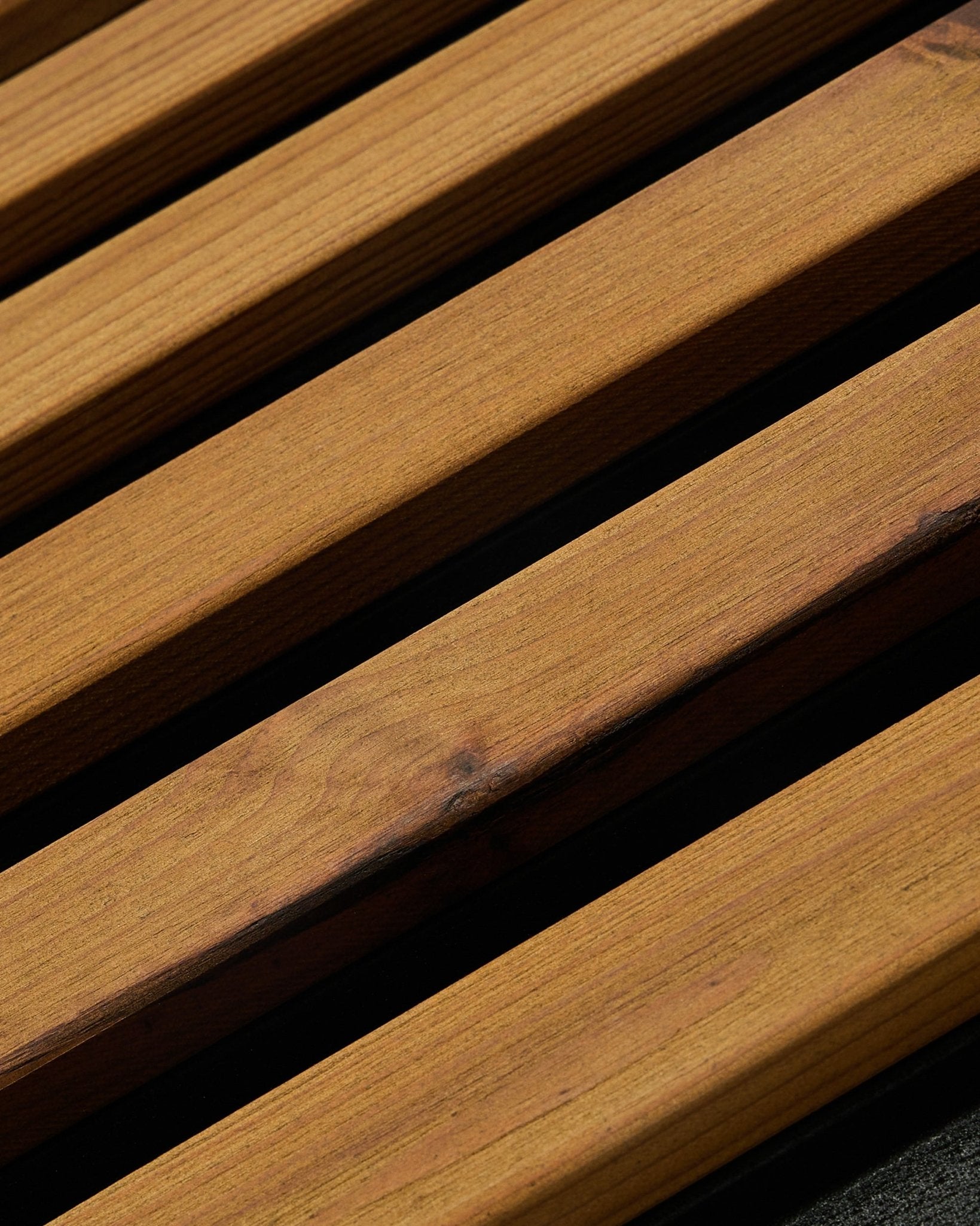 Akupanel acoustic wood slat panel in oiled brown with black gaps, close-up