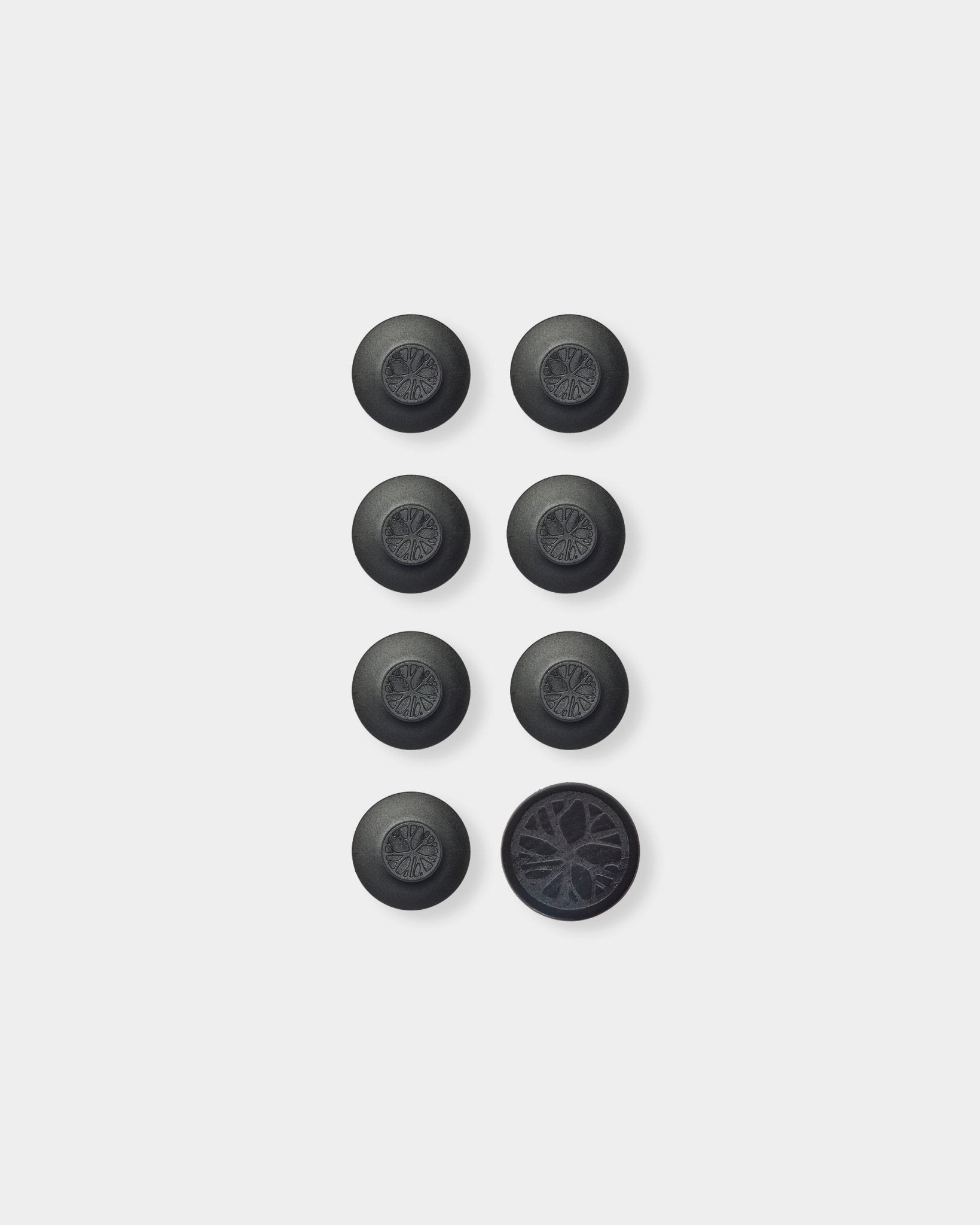 Black Dupps round accessories on plain white background, bottom right flipped to show underside