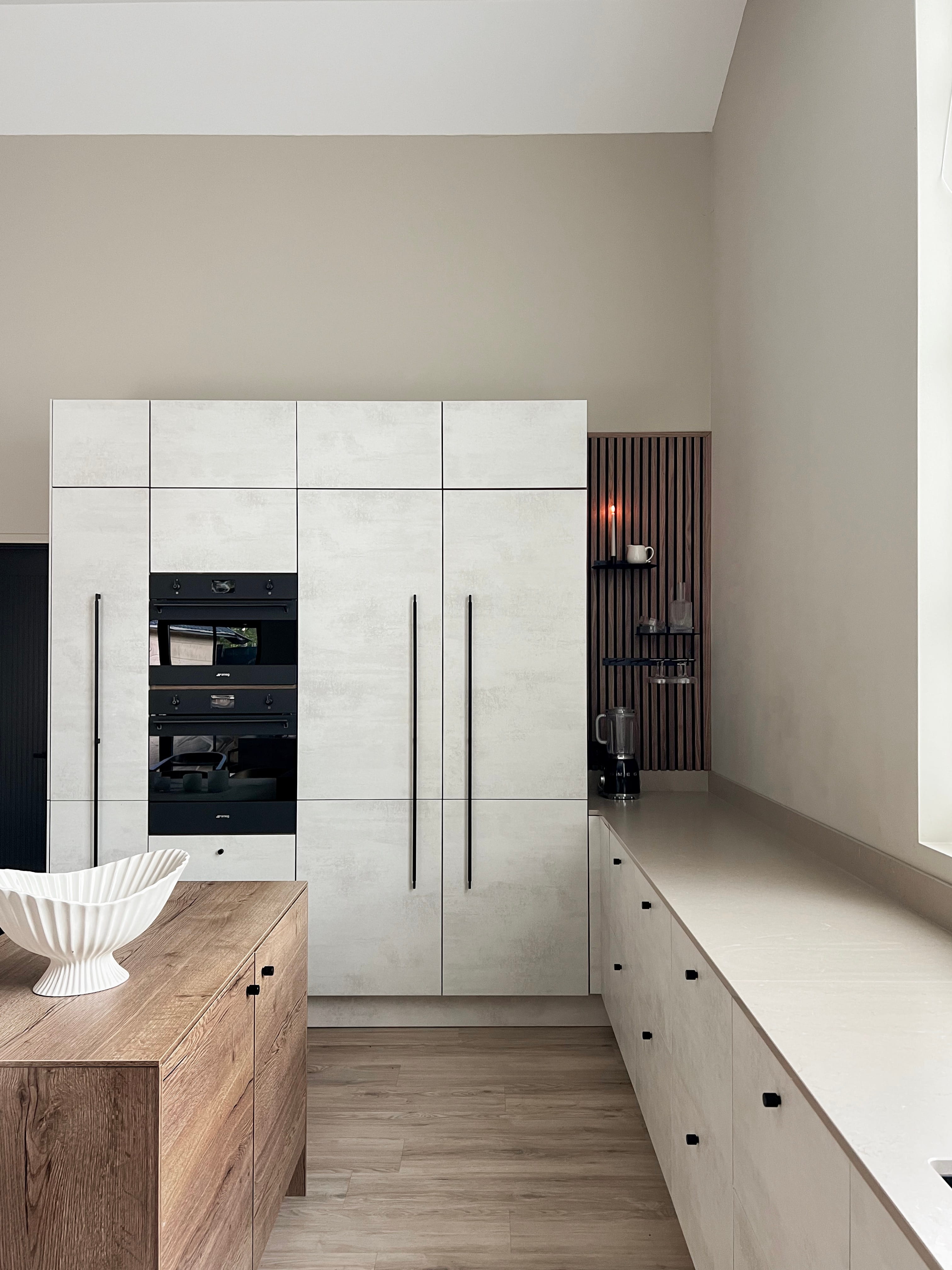 Akupanel wood slat acoustic panel set in a kitchen niche with black shelves and a mug.