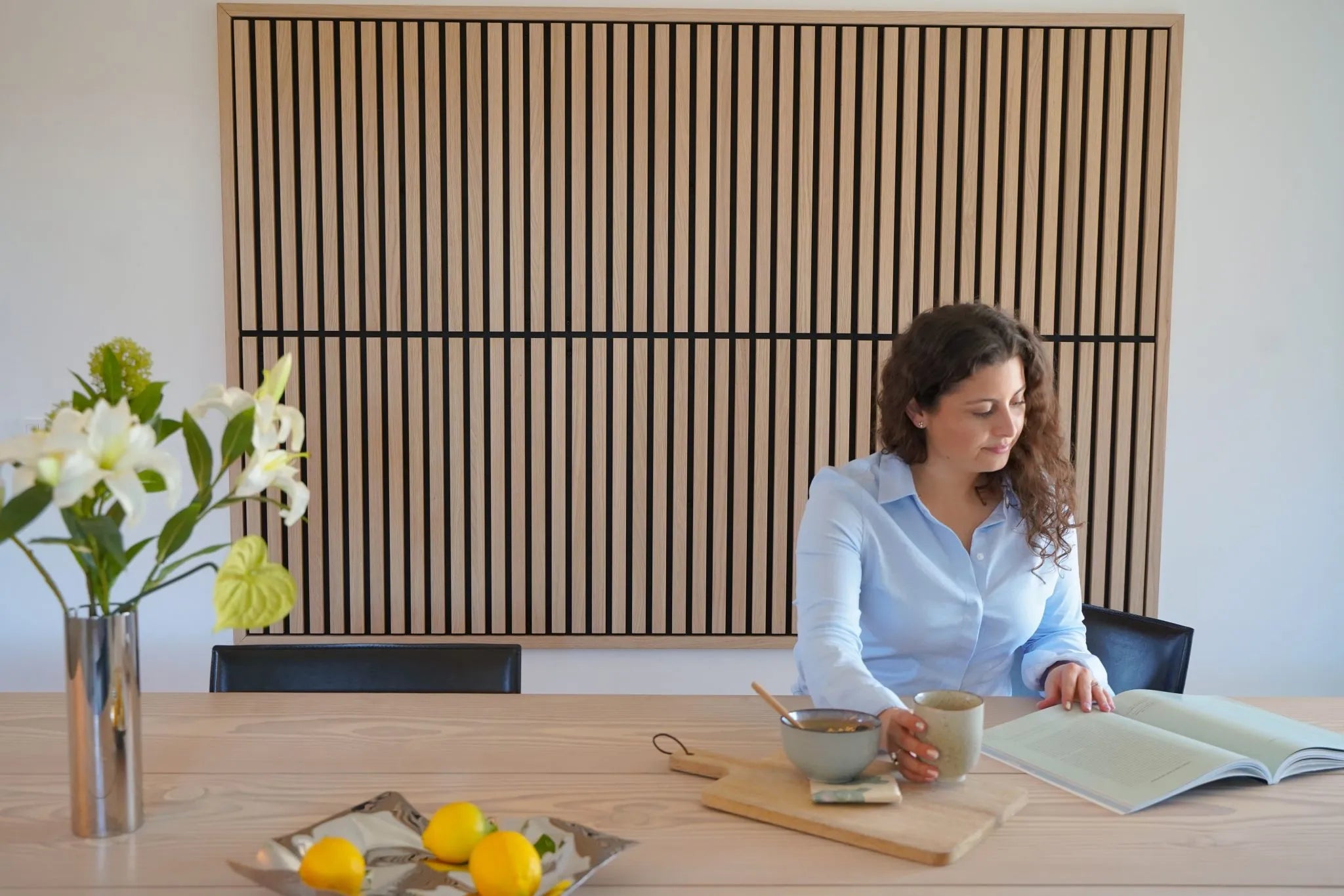 Akupanel wood slat acoustic panel with black backing on a white interior wall.