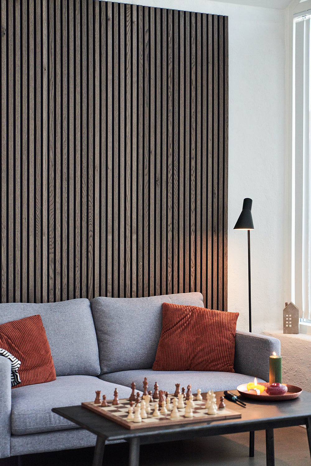 Akupanel acoustic slat wall, dark wood slats - living room with grey sofa, rust cushions and coffee table