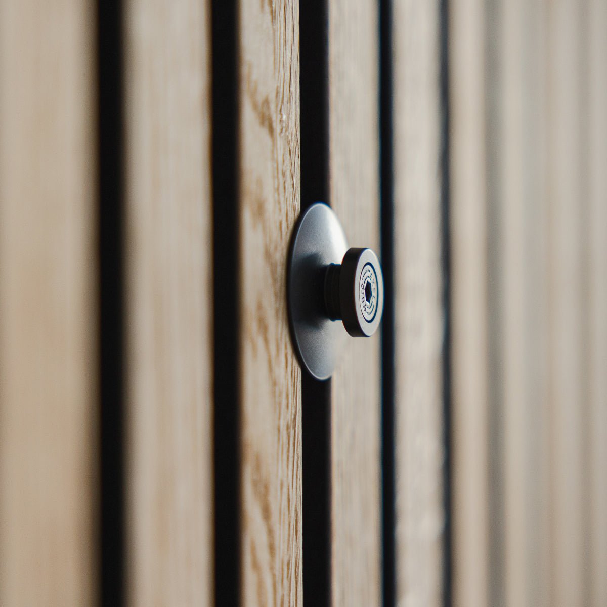 Black metal Dupps cable cover mounted on Akupanel acoustic wood slat wall